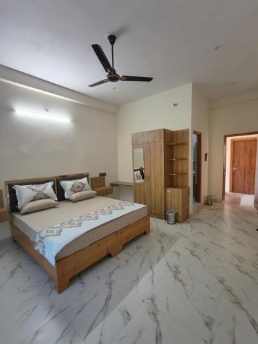 a bedroom with a bed and a ceiling fan at Da Sampurn Hotel in Tiuni