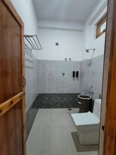 a bathroom with a toilet and a sink at Da Sampurn Hotel in Tiuni