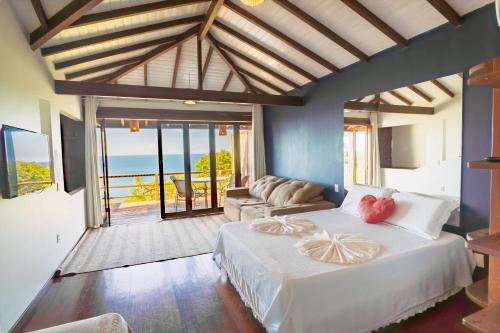 a bedroom with a bed and a living room at Villa Giulia Morro Residence in Morro de São Paulo