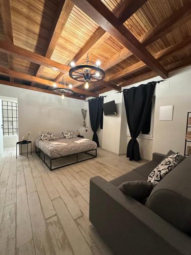 a bedroom with a bed and a couch in a room at Le Cantine della Nelli in Genoa
