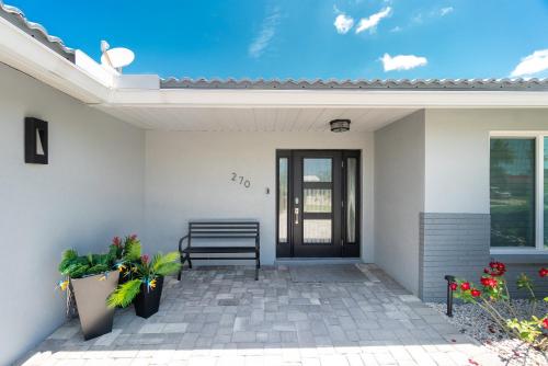 a porch of a house with a bench and flowers at Villa Tranquility-Waterfront-Free Amenities-Heated Pool-Bikes-Dock Fishing & Beach Gear in Punta Gorda