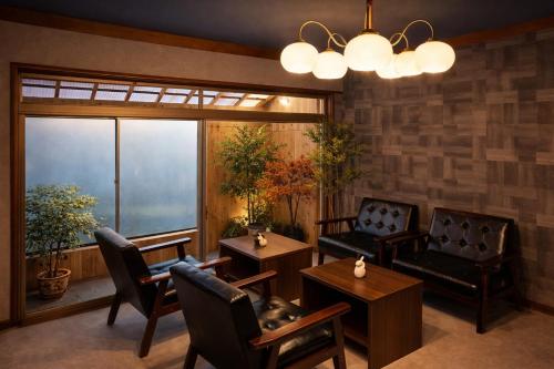a living room with furniture and a large window at 加美屋リゾート出雲大社神迎の道 杵と月 in Taisha