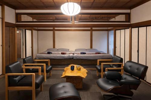 a room with a bed and a table and chairs at 加美屋リゾート出雲大社神迎の道 杵と月 in Taisha