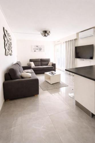 a living room with a couch and a table at Studio cosy, Centre Port, Piscine, proche plage in Cap d'Agde