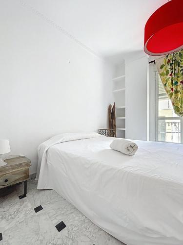 a white bedroom with a white bed and a red ceiling at Casa Patio de la Antigua in Iznájar