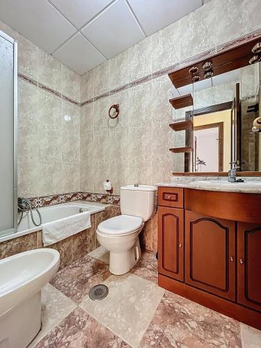 a bathroom with a toilet and a sink and a tub at Casa Patio de la Antigua in Iznájar