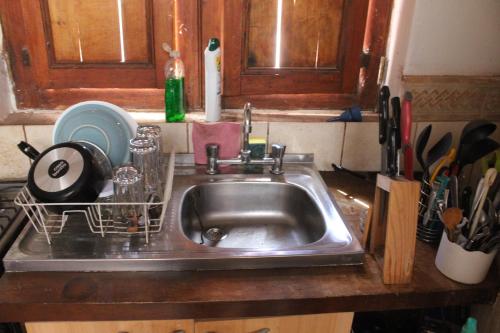 a kitchen sink with a dish rack next to it at Casa Garces in San Pedro de Atacama