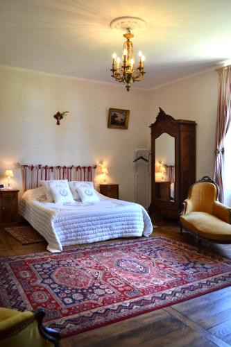 une chambre avec un lit et un lustre dans l'établissement Chambres d'Hôtes Launay Guibert, à Miniac-Morvan