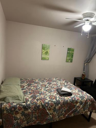 a bedroom with a bed with a comforter and a ceiling fan at Home sweet home in Thunder Bay