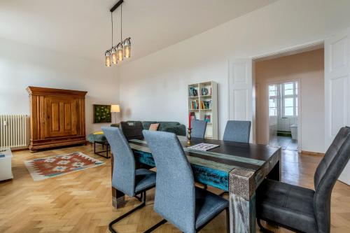 a living room with a dining room table and chairs at Fürstlich Wohnen am Circus mit Blick zur Granitz in Putbus