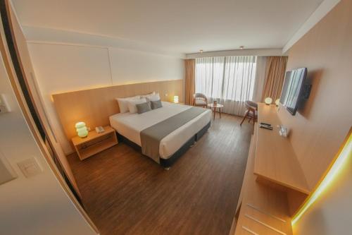 a hotel room with a bed and a television at Dazzler by Wyndham Lima Miraflores in Lima