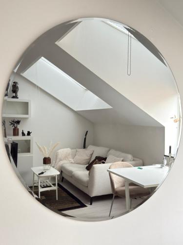 a living room with a white couch and a mirror at Penthouse Studio in Stockholm