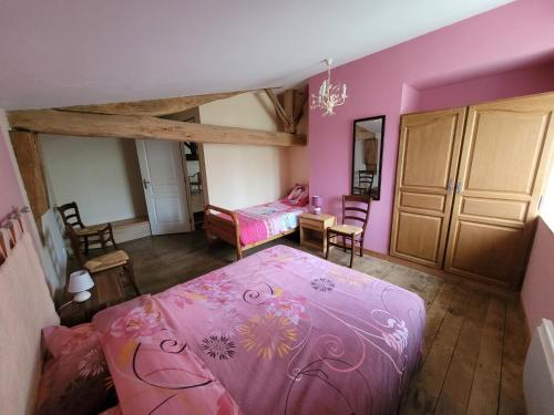 a bedroom with a pink bed and a desk at Gîte de La Rev'rie in Montalembert