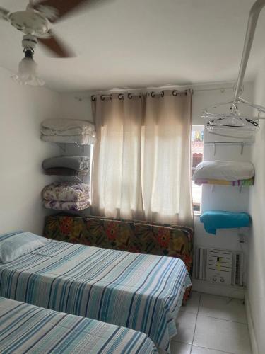 a small room with two beds and a window at Casa condomínio Praia do Jardim in Angra dos Reis