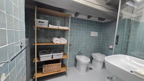 a blue tiled bathroom with a toilet and a sink at Fontana Maggiore View Suite in Perugia