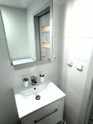 a white bathroom with a sink and a mirror at Domov na cestě in Rousovice