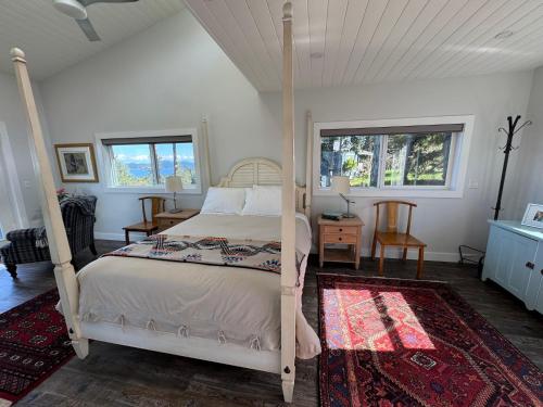 a bedroom with a bed and two windows at Salt Spring Sunrise in Saltspring Island