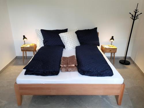 a bed with black and white sheets and pillows at Domov na cestě in Rousovice