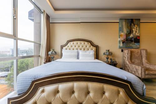 a bedroom with a large bed with a large window at Hotel Du Parc in Medellín