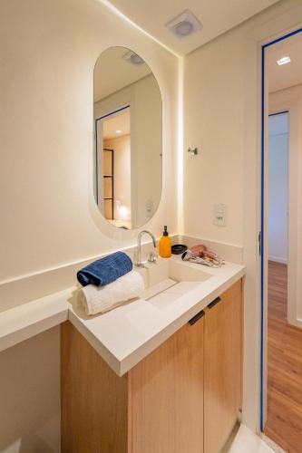 a bathroom with a sink and a mirror at apartamento em Itaipava novo, Granja Brasil Resort in Petrópolis