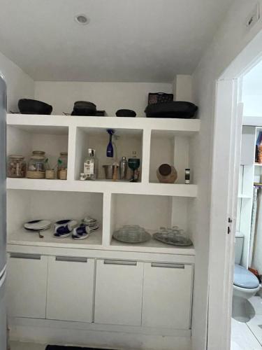 a white shelf with dishes and bowls on it at Casa condomínio Praia do Jardim in Angra dos Reis