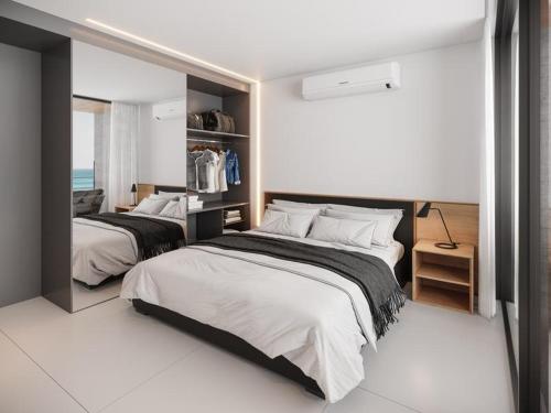 a bedroom with two beds and a mirror at Flat em Porto life Resort in Porto De Galinhas