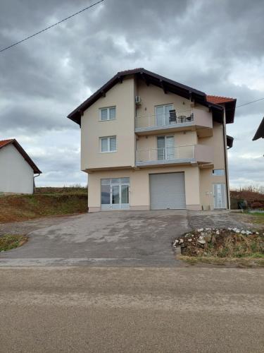 a large house with a large parking lot at Apartmani Halilčević in Dubrave Gornje