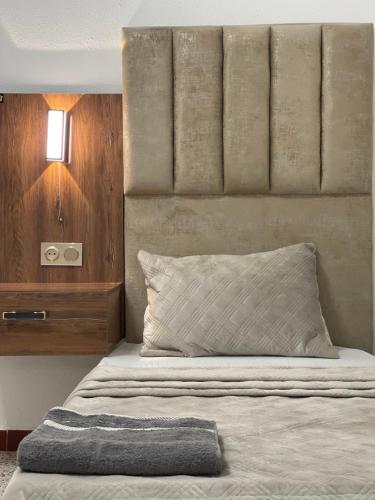 a bedroom with a bed with a wooden headboard at Hotel grosvenor in Saint-Arnaud