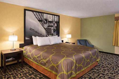 a hotel room with a large bed and two lamps at Super 8 by Wyndham Pasadena in Pasadena