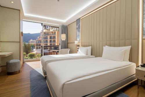 a bedroom with a large bed and a large window at Merit Crystal Cove Hotel Casino & SPA in Kyrenia