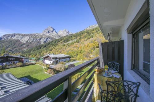 a balcony with a table and chairs and mountains at Résidence Igloo in Le Tour