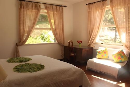 a bedroom with two beds and a window at Sítio p/ Casamentos 8 min do Centro de Petrópolis in Petrópolis