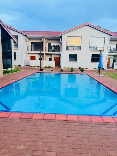 a swimming pool in front of a house at Gate Beautiful in Gaborone
