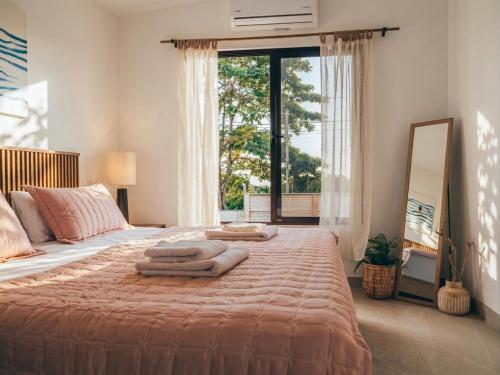 a bedroom with a large bed with towels on it at Villa Ticalma in Parrita