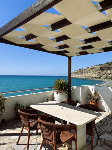 a patio with a table and chairs and the ocean at Blue Sea in Ierapetra