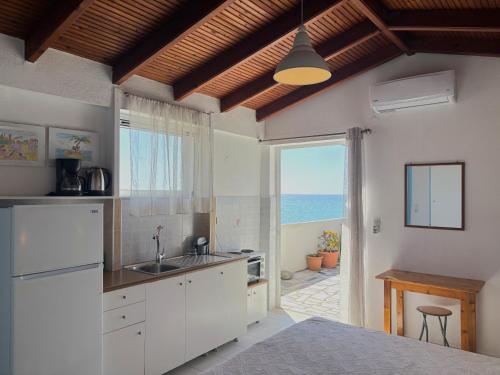 a kitchen with white cabinets and a view of the ocean at Blue Sea in Ierapetra