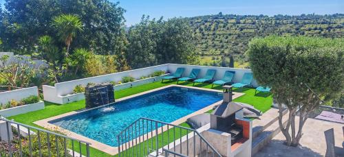 a swimming pool in a yard with chairs around it at The View House in Albufeira