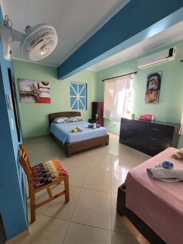 a room with two beds and a chair in it at B&B Pavillion in Sosúa