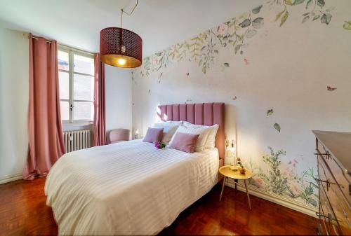 a bedroom with a bed with white sheets and flowers on the wall at Volto Santo - Sacred Residence - Piazza Maggiore in Bologna