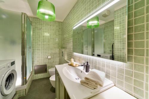 a bathroom with a sink and a washing machine at Volto Santo - Sacred Residence - Piazza Maggiore in Bologna