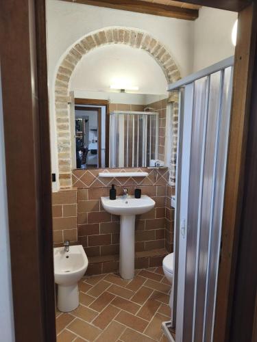 a bathroom with a sink and a toilet and a mirror at Il Quercetino di Momo in Ravenna