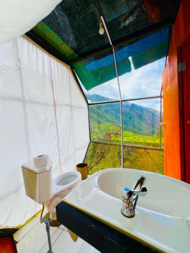 a bathroom with a sink and a toilet in a tent at Hanging Nest Salkantay in Colcapampa