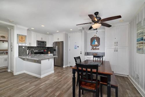 a kitchen with a table and a ceiling fan at Oceanside Cozy Fun and Resortsy Getaway in Oceanside