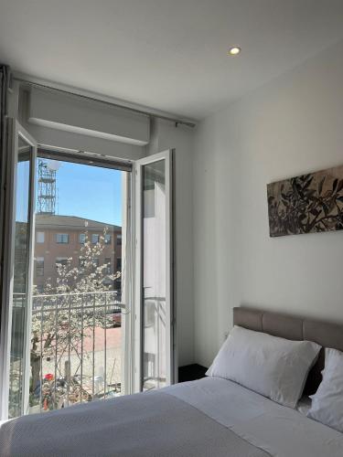 a bedroom with a bed and a large window at Villa Ibra - Rho Fiera & Milano, Garden & Parking in Paderno Dugnano