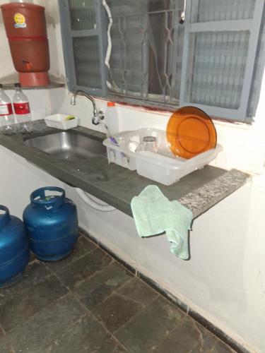 a kitchen counter with a sink and a toilet at Pousada Cantinho da Idná in Uberlândia