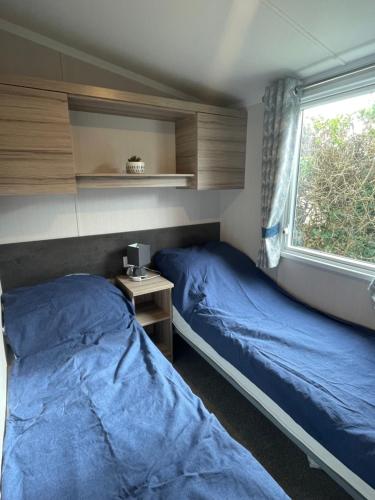 a bedroom with two beds and a window at Polls Place in Caernarfon