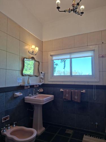 a bathroom with a sink and a toilet and a window at VersionMoreno apart hotel in General Villegas