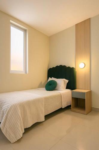 a bedroom with a bed with a green headboard and a window at Estancia Dorada in San Ramón