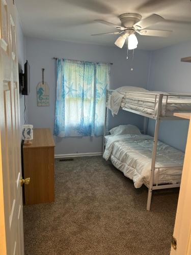 a bedroom with a bunk bed and a ceiling fan at 3 bed room lake cottage in Geneva