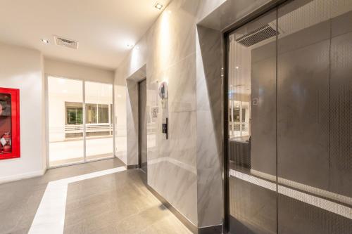 a hallway with glass doors in a building at Paeva Luxury By Nakra Functionality in Bang Bo